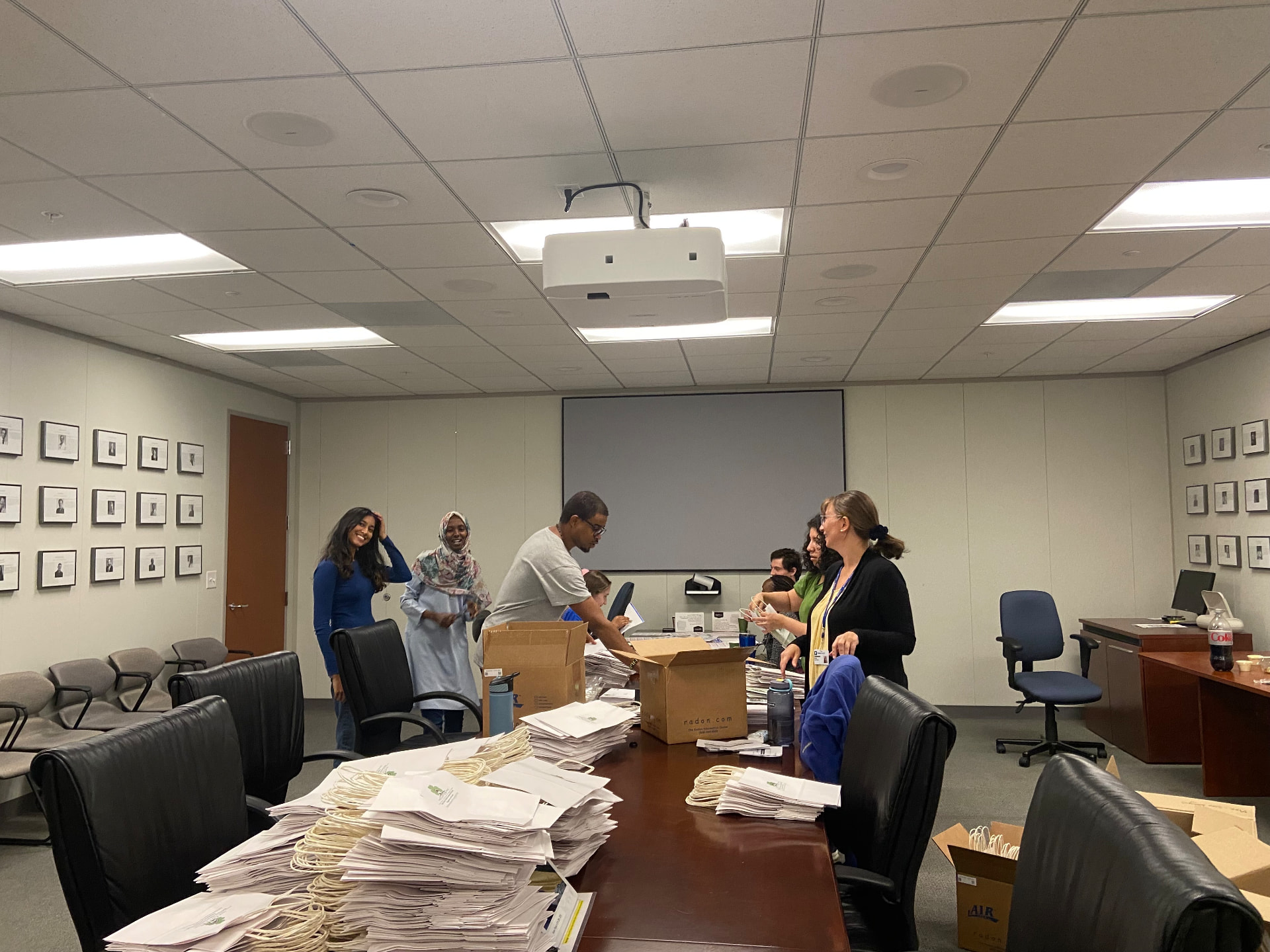 Team members packing study mailings into envelopes around a conference table