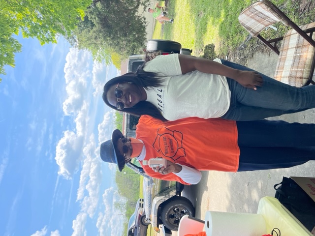 A REGAL team member in a REGAL t-shirt with a Caswell County cancer support group volunteer at an outdoor giveaway