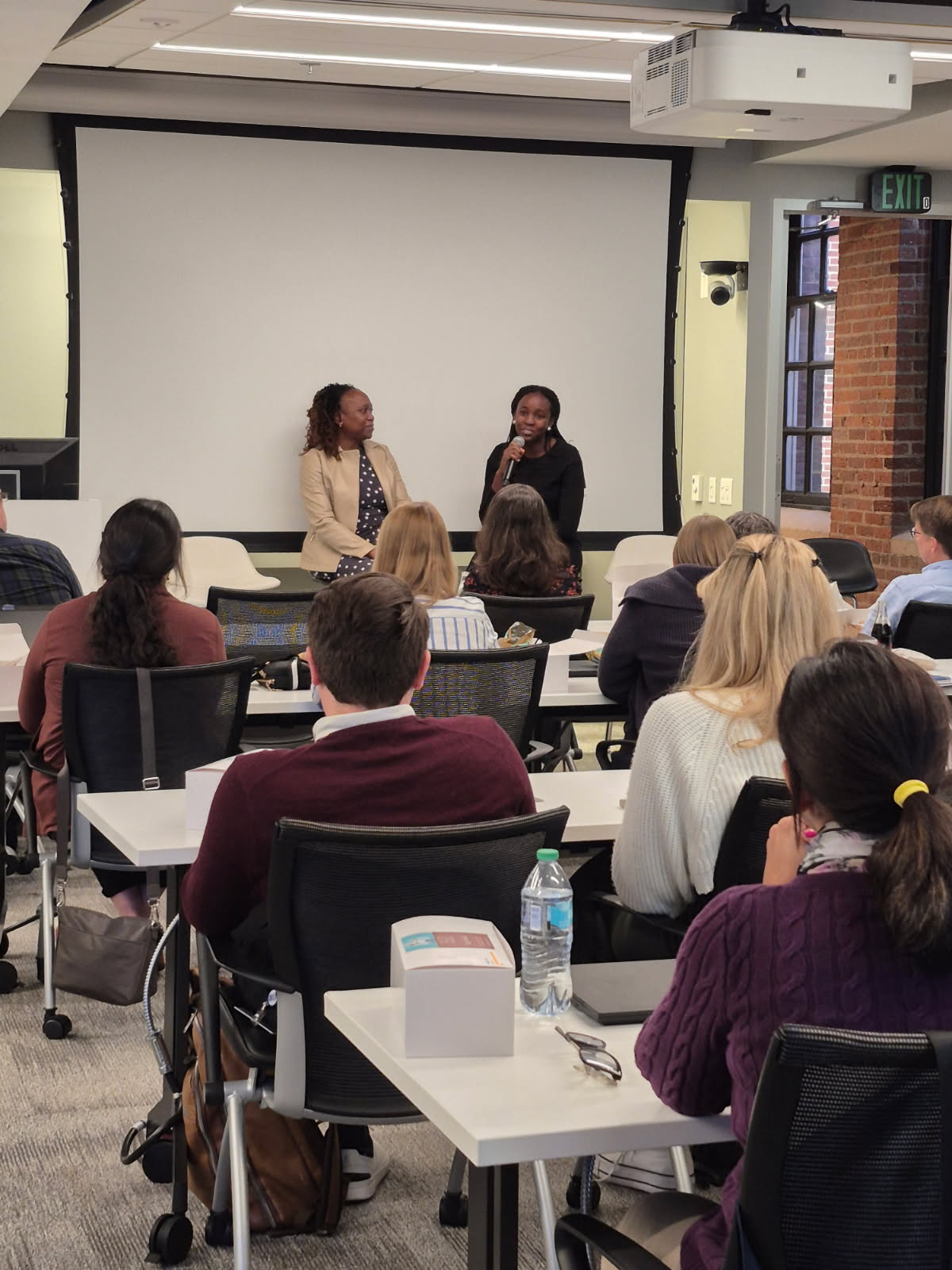 Two REGAL researchers answering questions in front of a seated audience at a department event